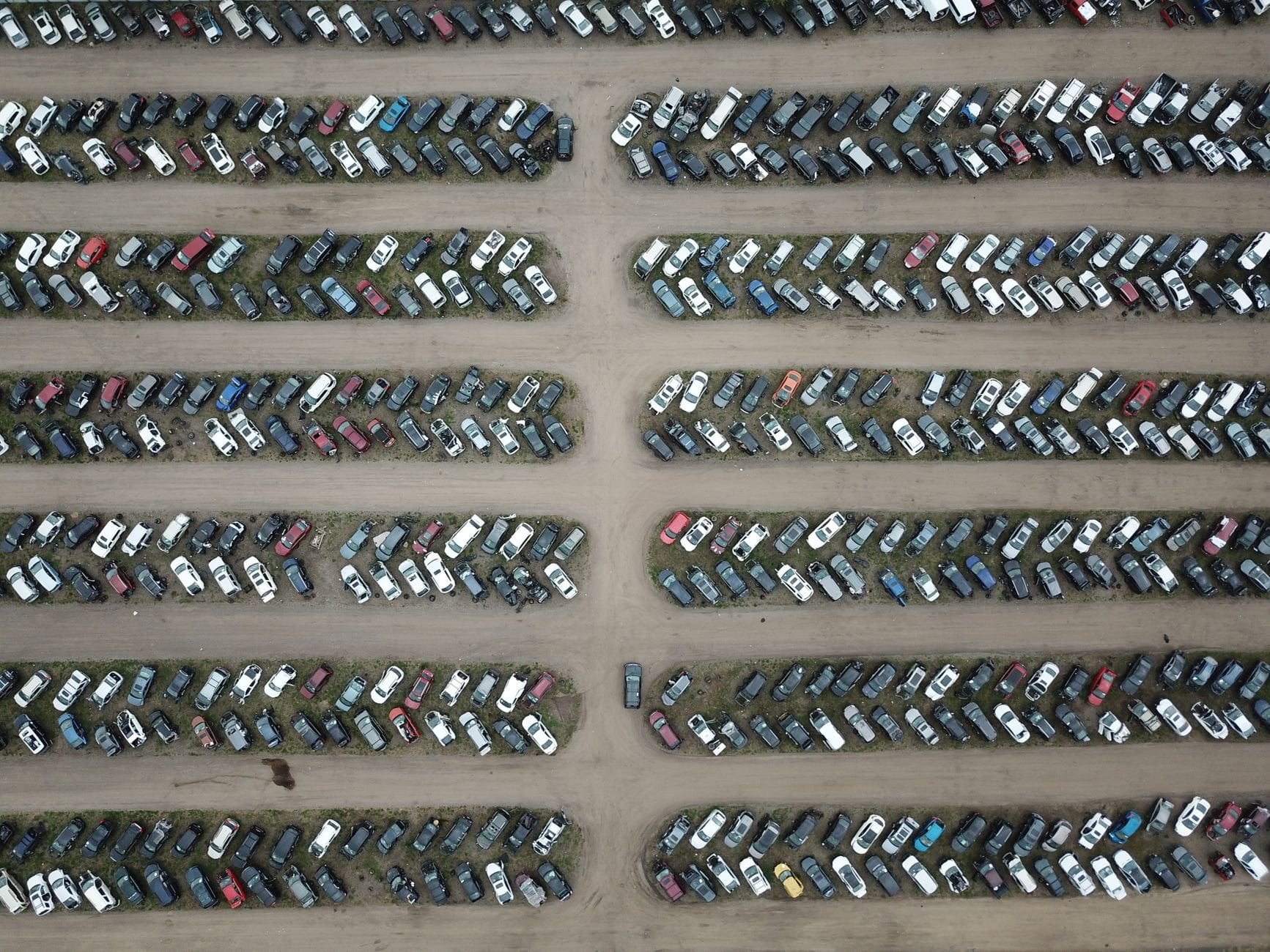 High angle view of numerous vehicles in an organised car lot, showcasing variety.